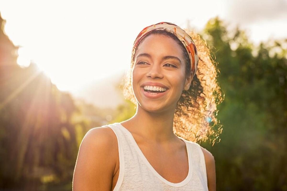 uma mulher está sorrindo enquanto usa uma faixa na cabeça