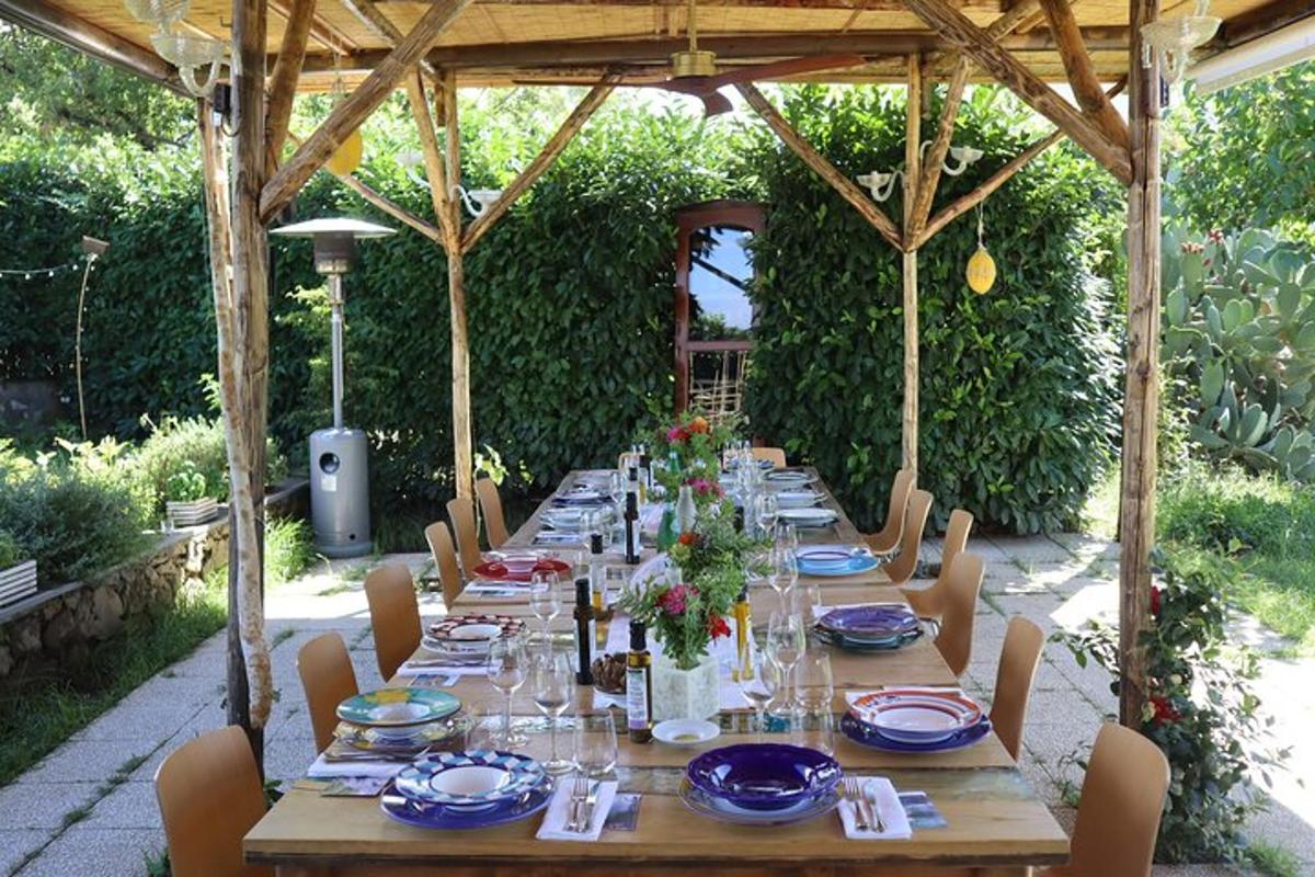 a long wooden table with plates and flowers on it