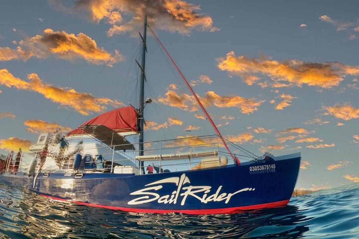 una barca blu in acqua con un cielo nuvoloso