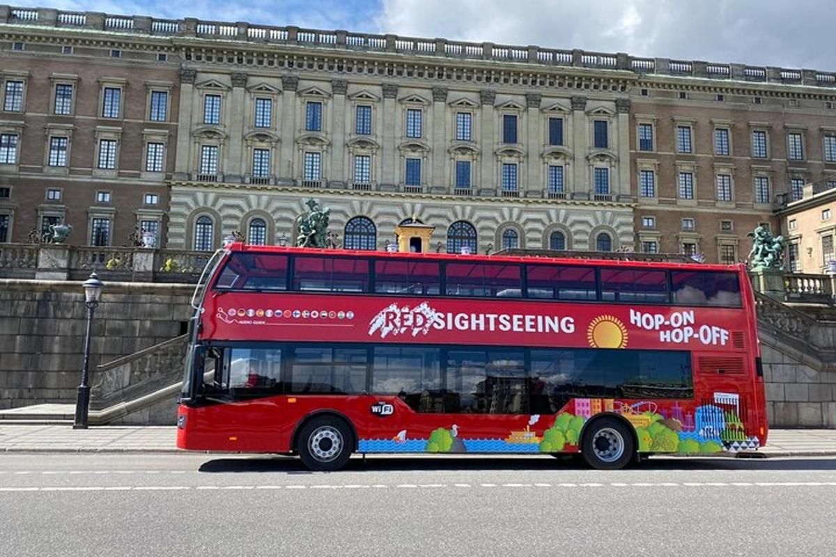 a red double decker bus parked in front of a building