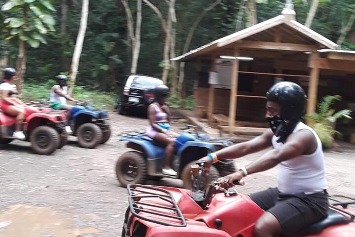 un uomo che guida un quad rosso con delle persone a bordo