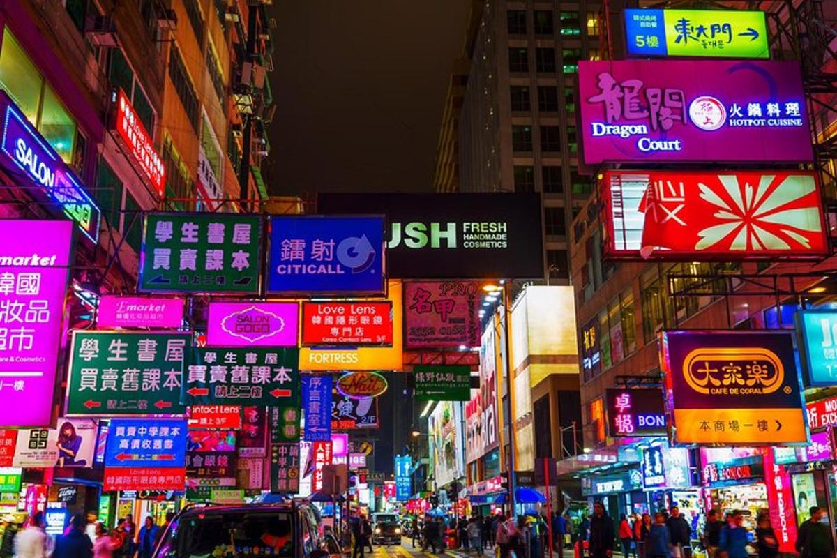 jalan bandar yang sibuk pada waktu malam dengan papan tanda neon