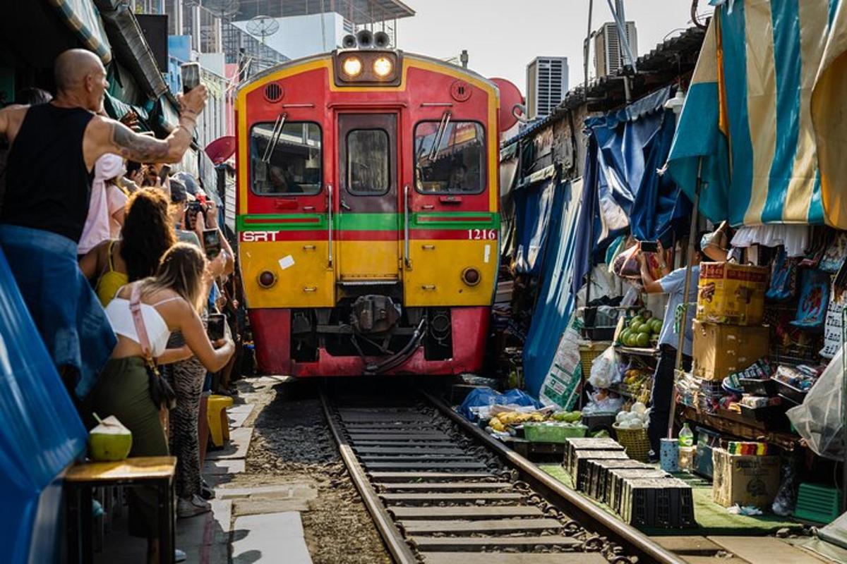 市场里，一列火车在铁轨上行驶，人群熙熙攘攘