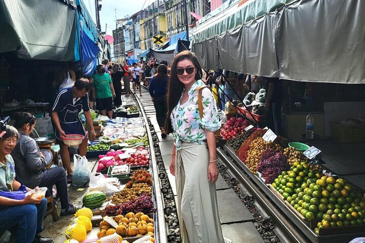 一位妇女站在市场里，卖着水果和蔬菜