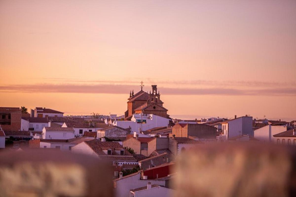 a view of a city at sunset with a church