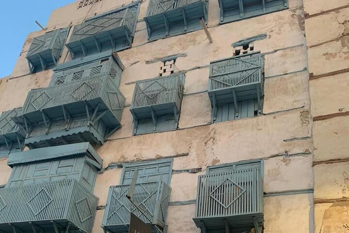 a tall building with green windows and balconies