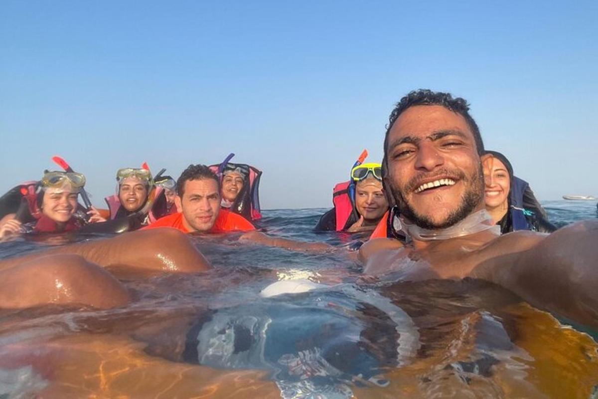 un gruppo di persone in acqua con un ippopotamo