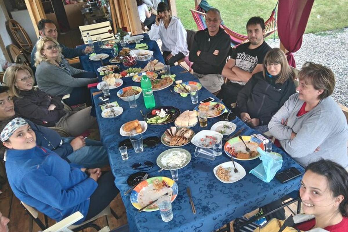 skupina lidí sedících kolem modrého stolu s jídlem