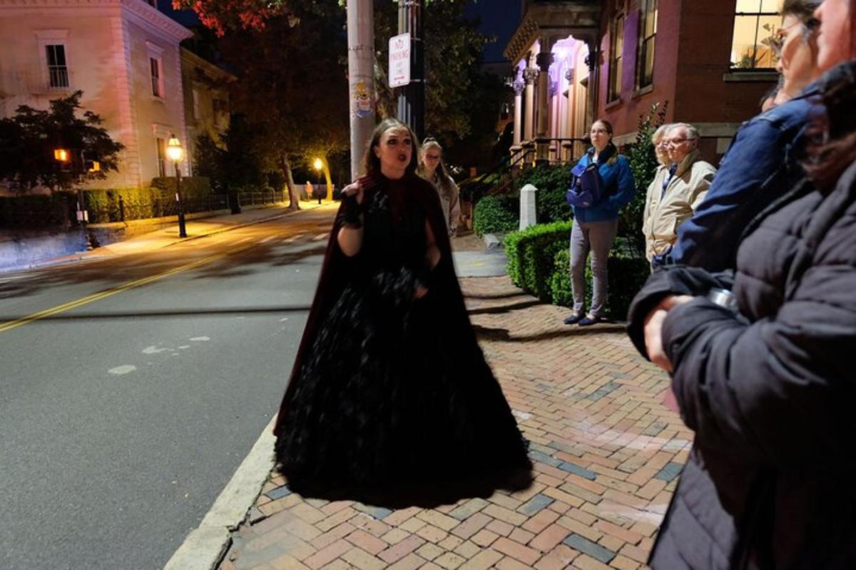a woman in a black dress standing on the street