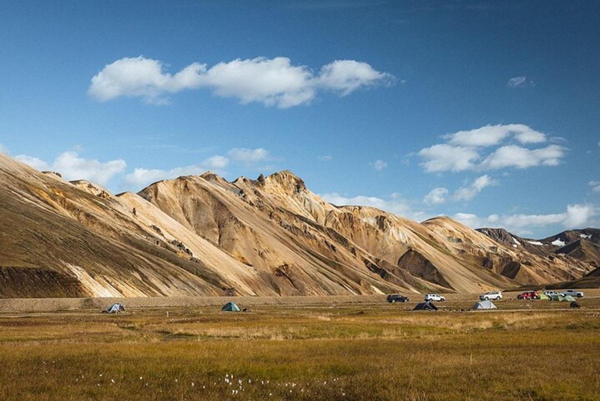 Un grupo de tiendas de campaña frente a una cordillera