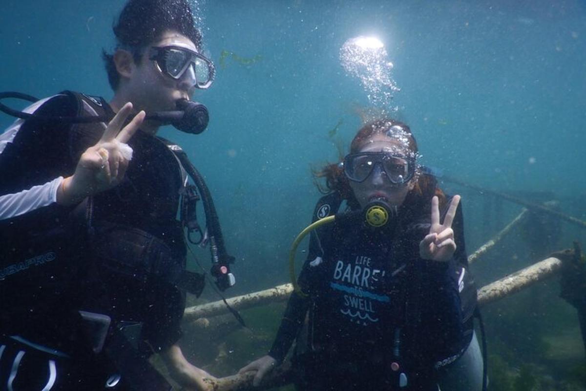 two people standing in the water giving the peace sign