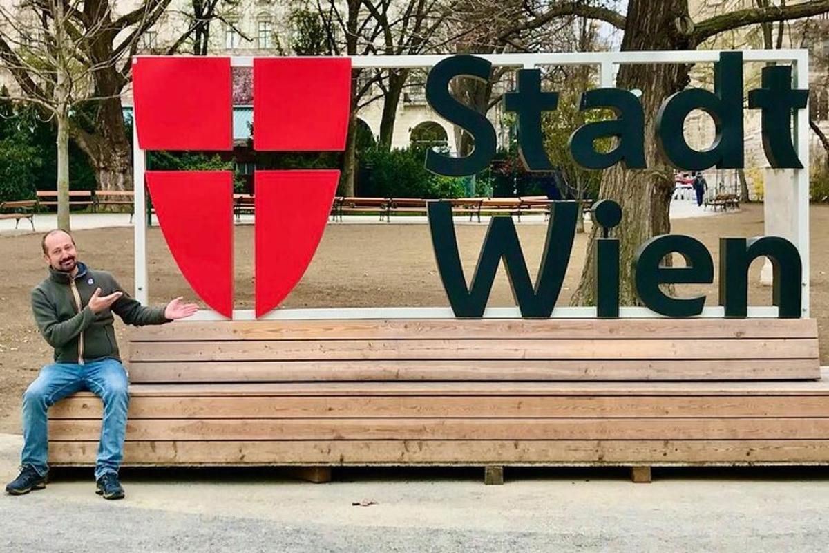 ein Mann sitzt auf einer Bank vor einem Schild