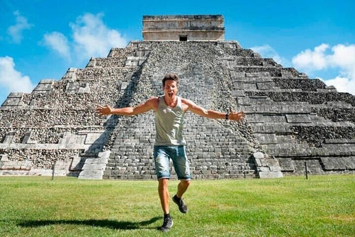 um homem em pé em frente a uma pirâmide