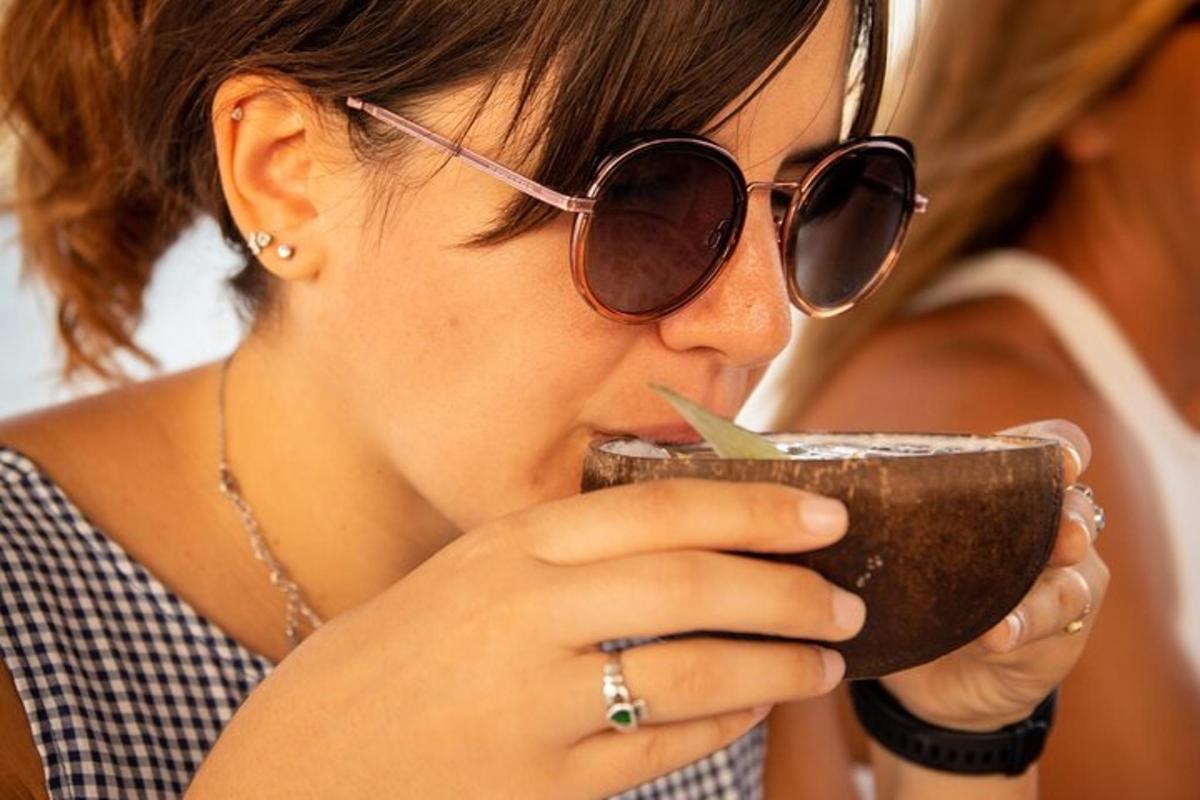 seorang wanita memakai cermin mata hitam minum dari cawan kopi