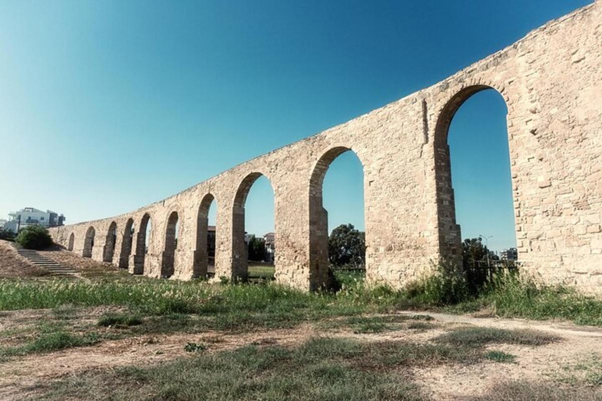 Una larga pared de ladrillos con tres arcos.