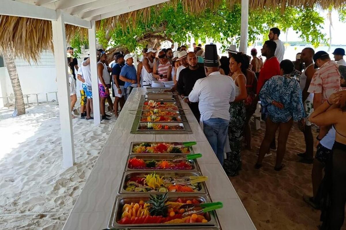 a group of people standing around a table of food