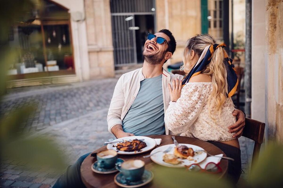un homme et une femme assis à une table avec de la nourriture