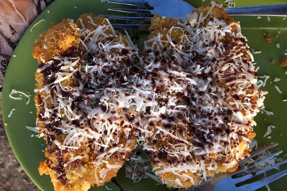 a green plate with a piece of food with a fork