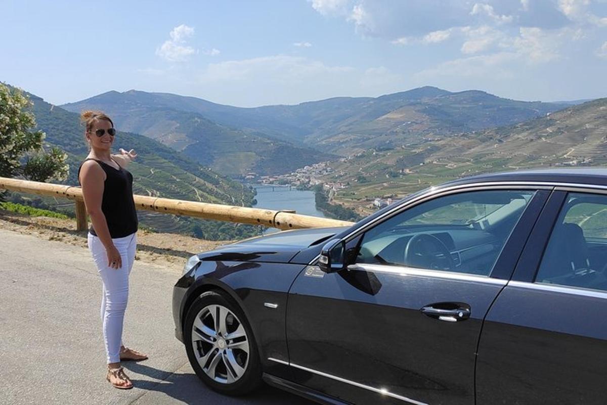 a woman standing next to a car on a road