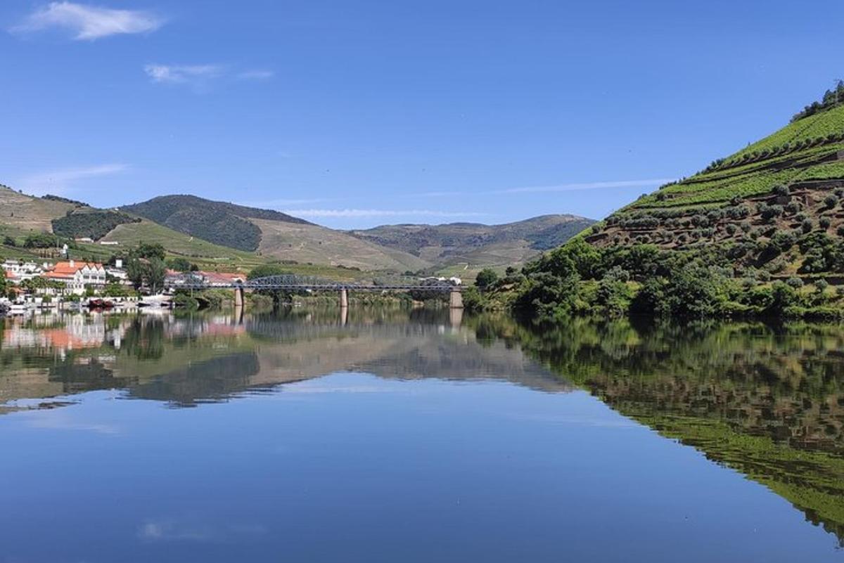 a river with a bridge and hills in the background
