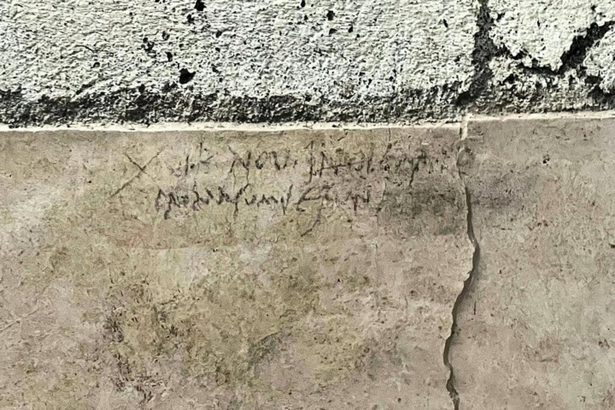 egy régi betonfal, rajta felirattal
