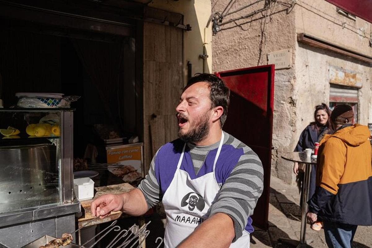 egy kötényes férfi ételt tesz a sütőbe
