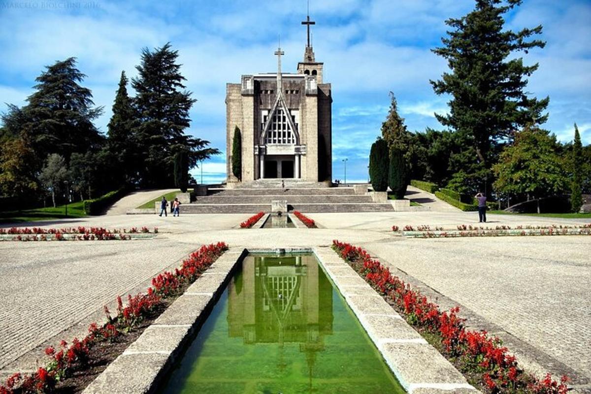 un edifici amb una torre del rellotge i flors al davant