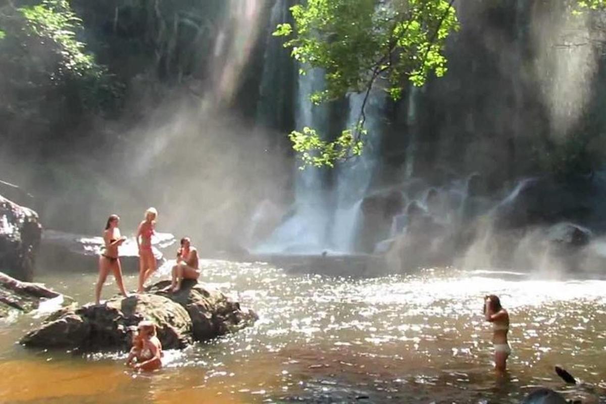 un groupe de personnes dans l'eau près d'une cascade
