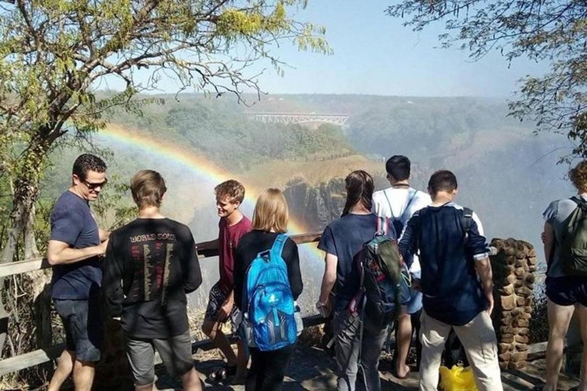 a group of people standing in front of a rainbow