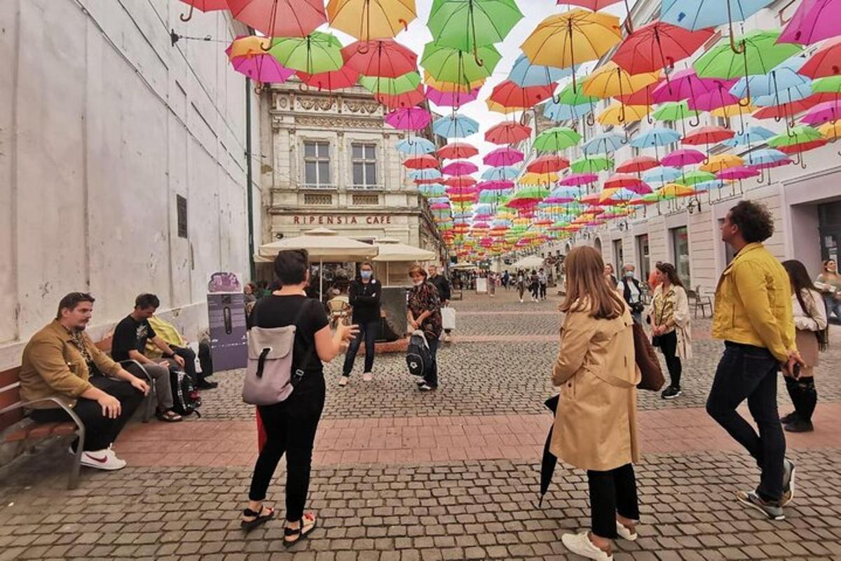 grupp inimesi, kes kõnnivad mööda tänavat vihmavarjude all