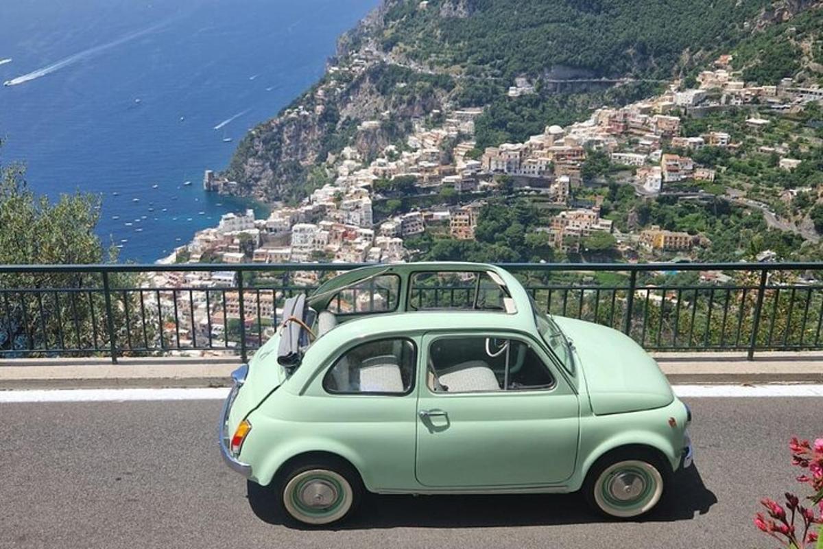 Un pequeño coche verde aparcado en la ladera de una montaña.