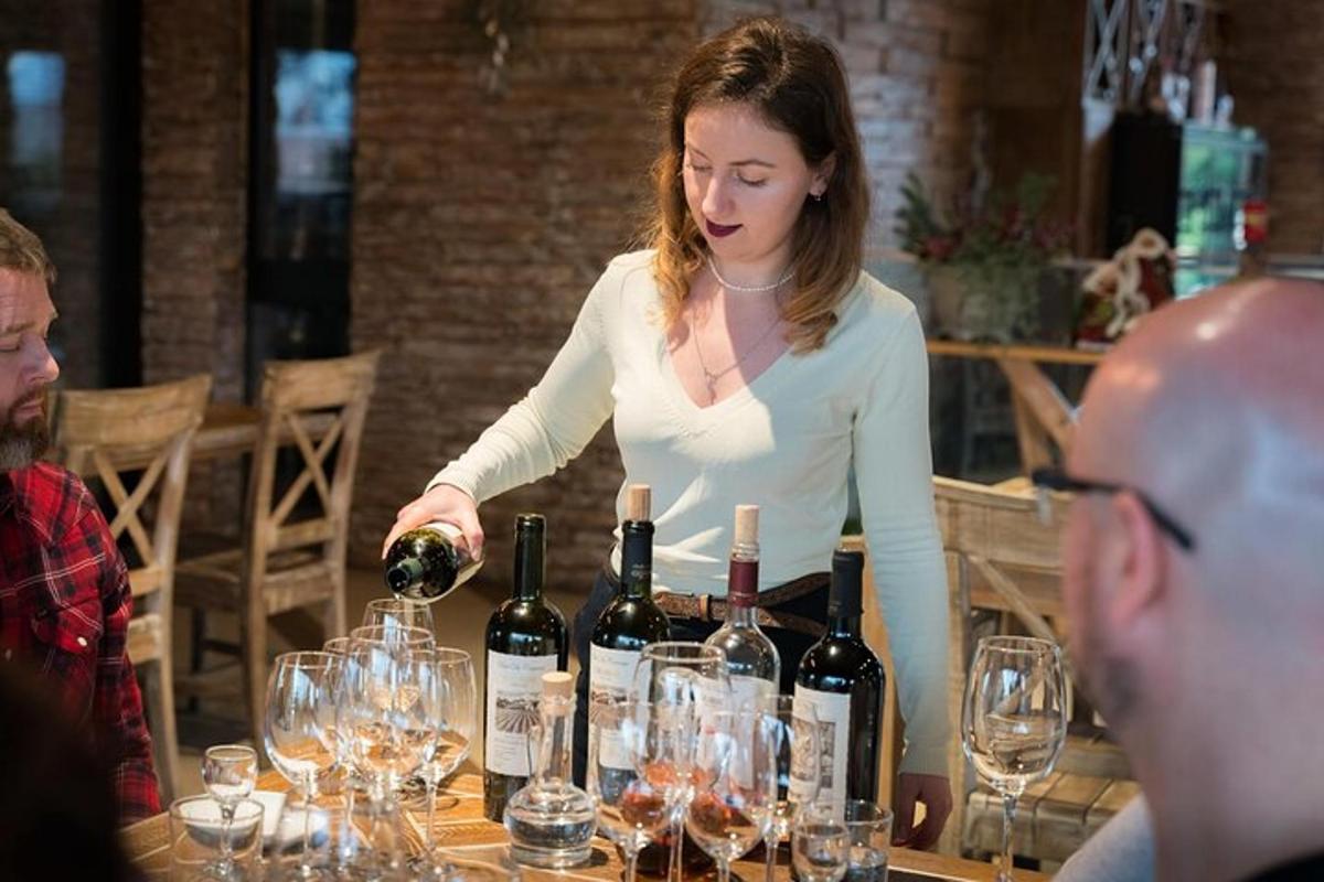 žena nalévá víno do stolu s vinnými sklenicemi