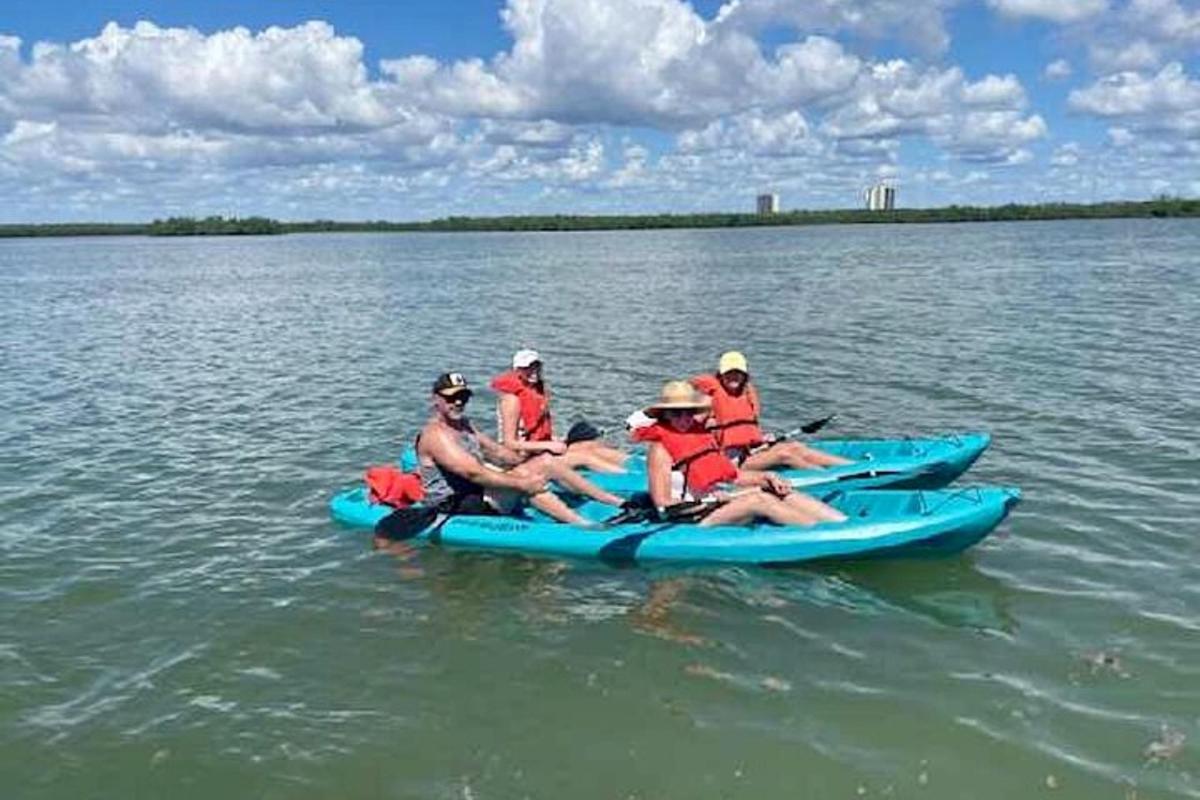 a group of people riding on a blue kayak in the water