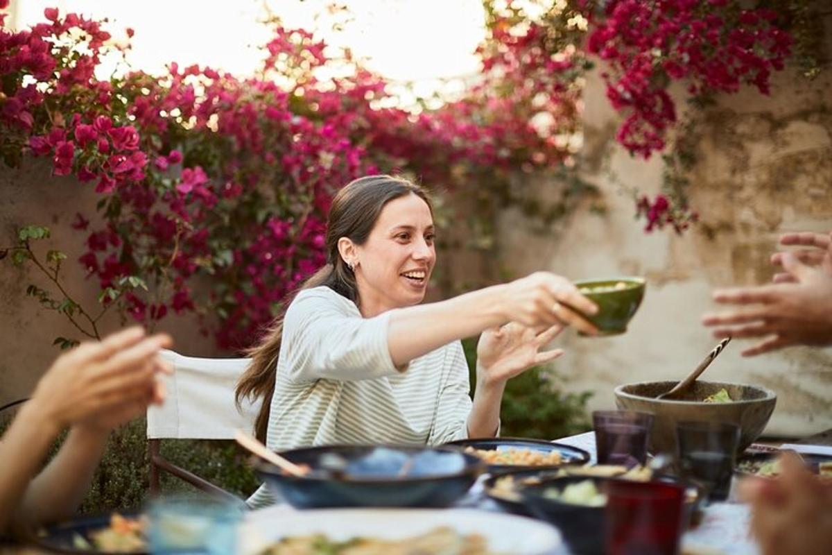 a woman holding a bowl of food at a table