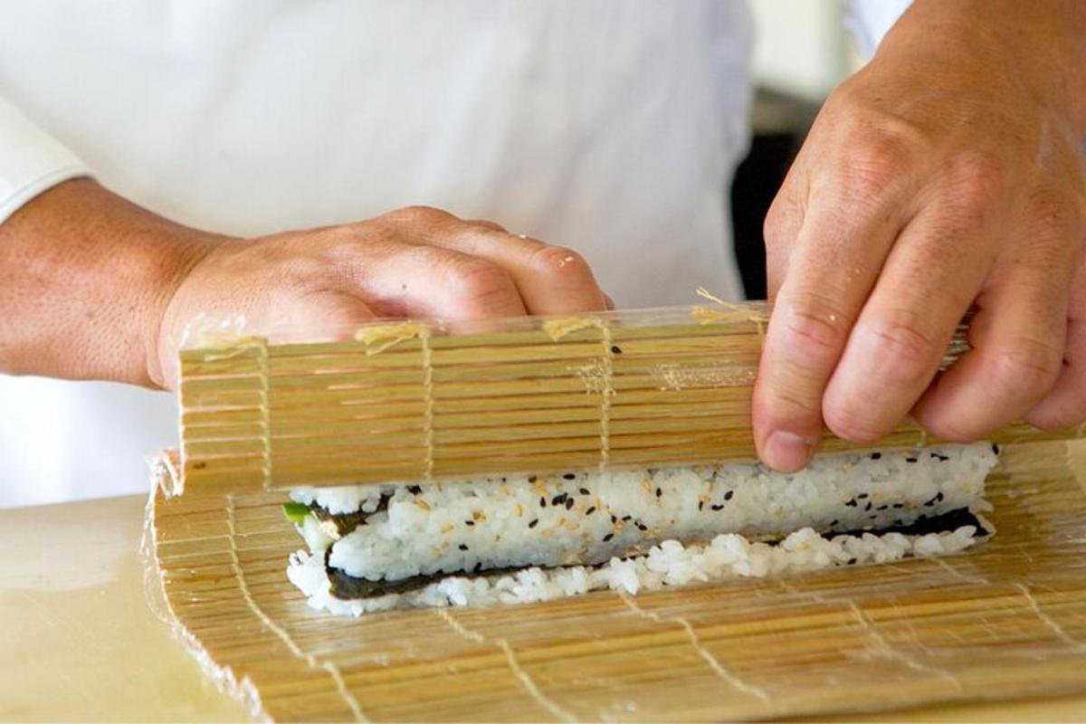 a chef is making sushi in a bamboo basket
