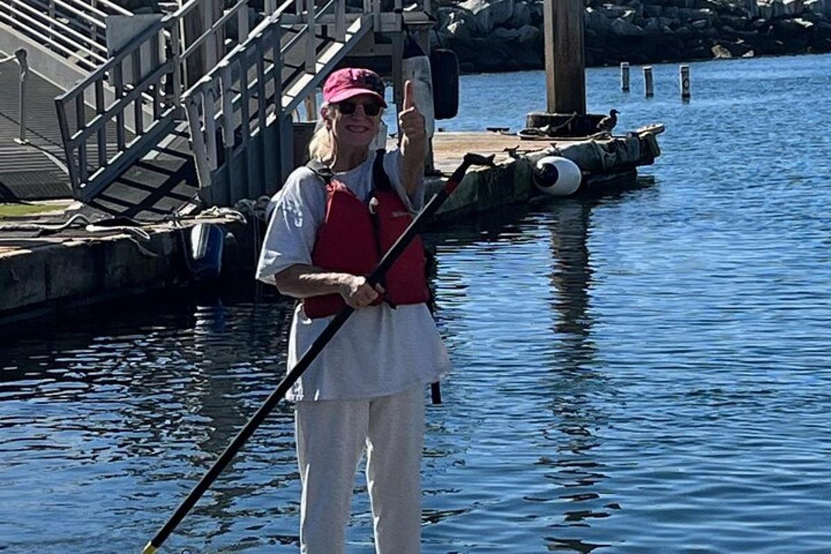 una donna in piedi nell'acqua che tiene in mano una pagaia
