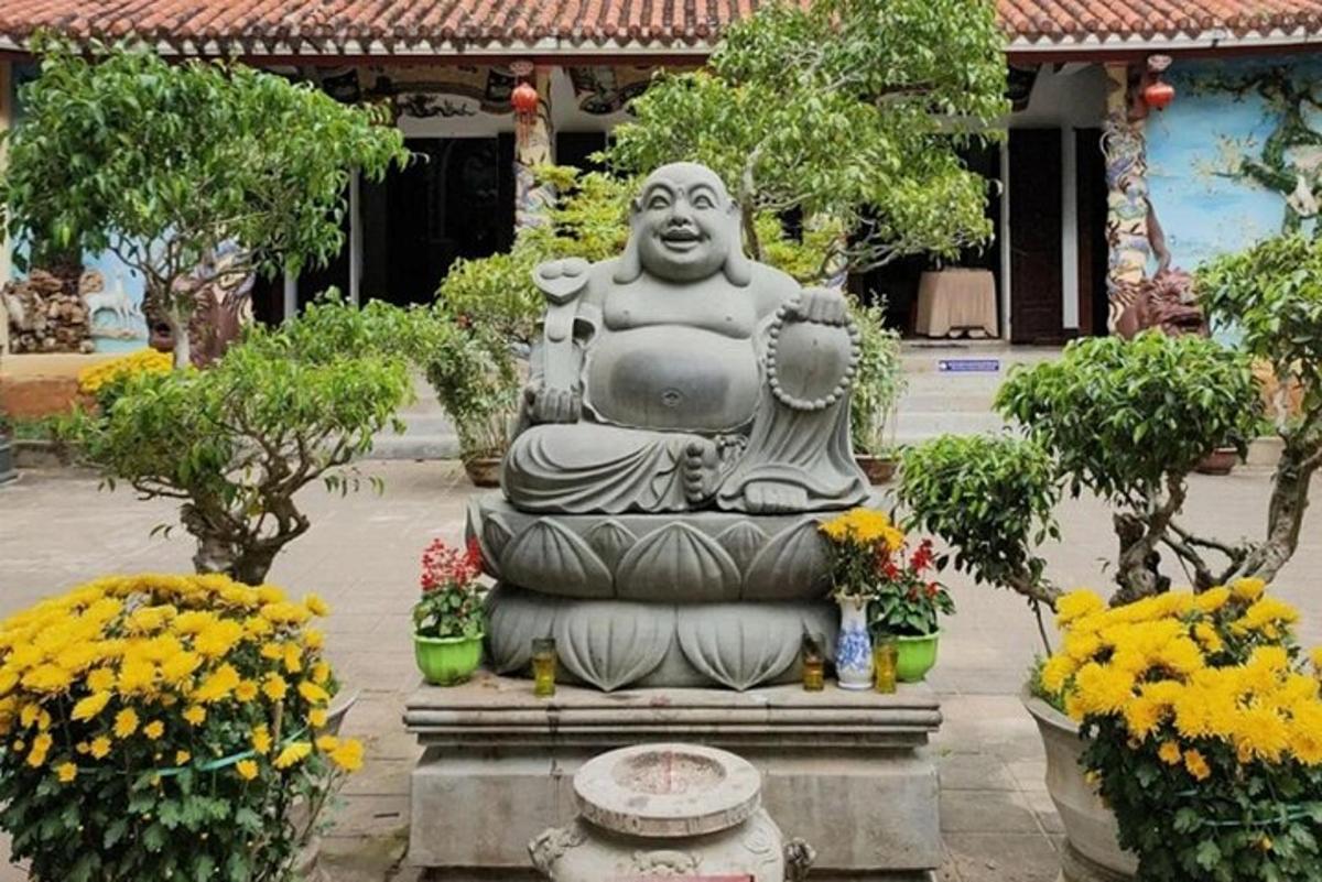 patung batu besar di halaman dengan bunga