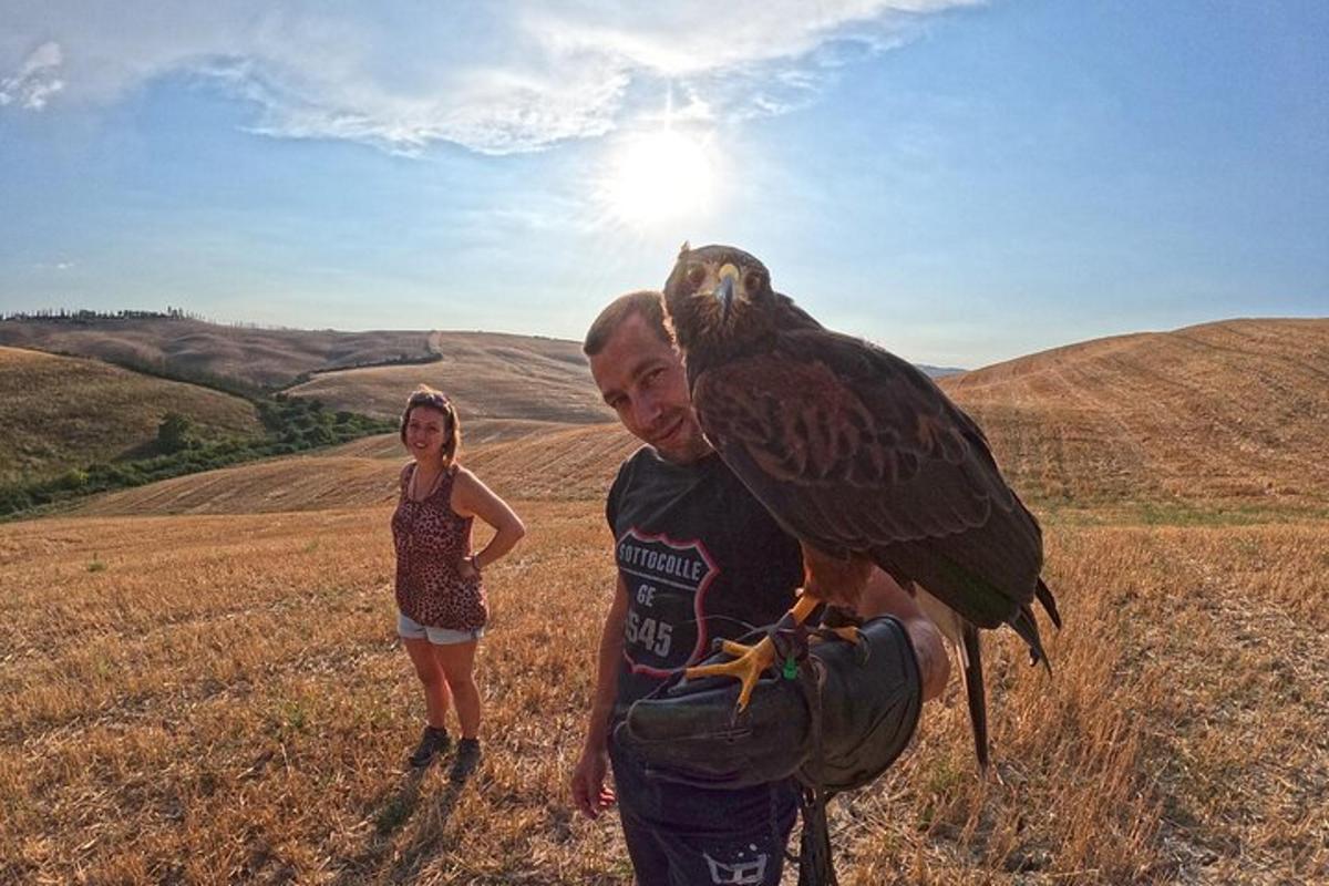 a man holding a bird on his shoulder with a girl