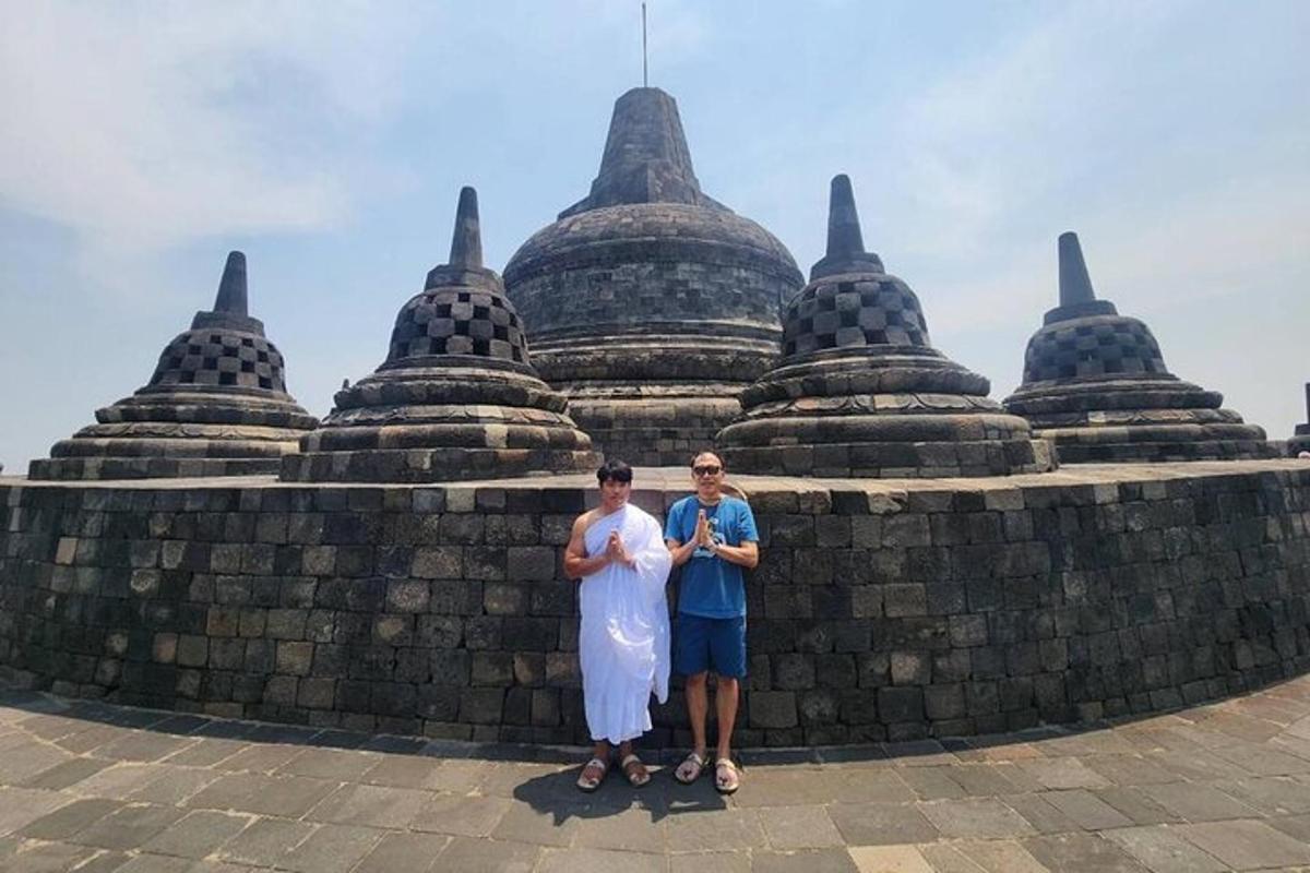 dua orang berdiri di hadapan dinding di hadapan bangunan