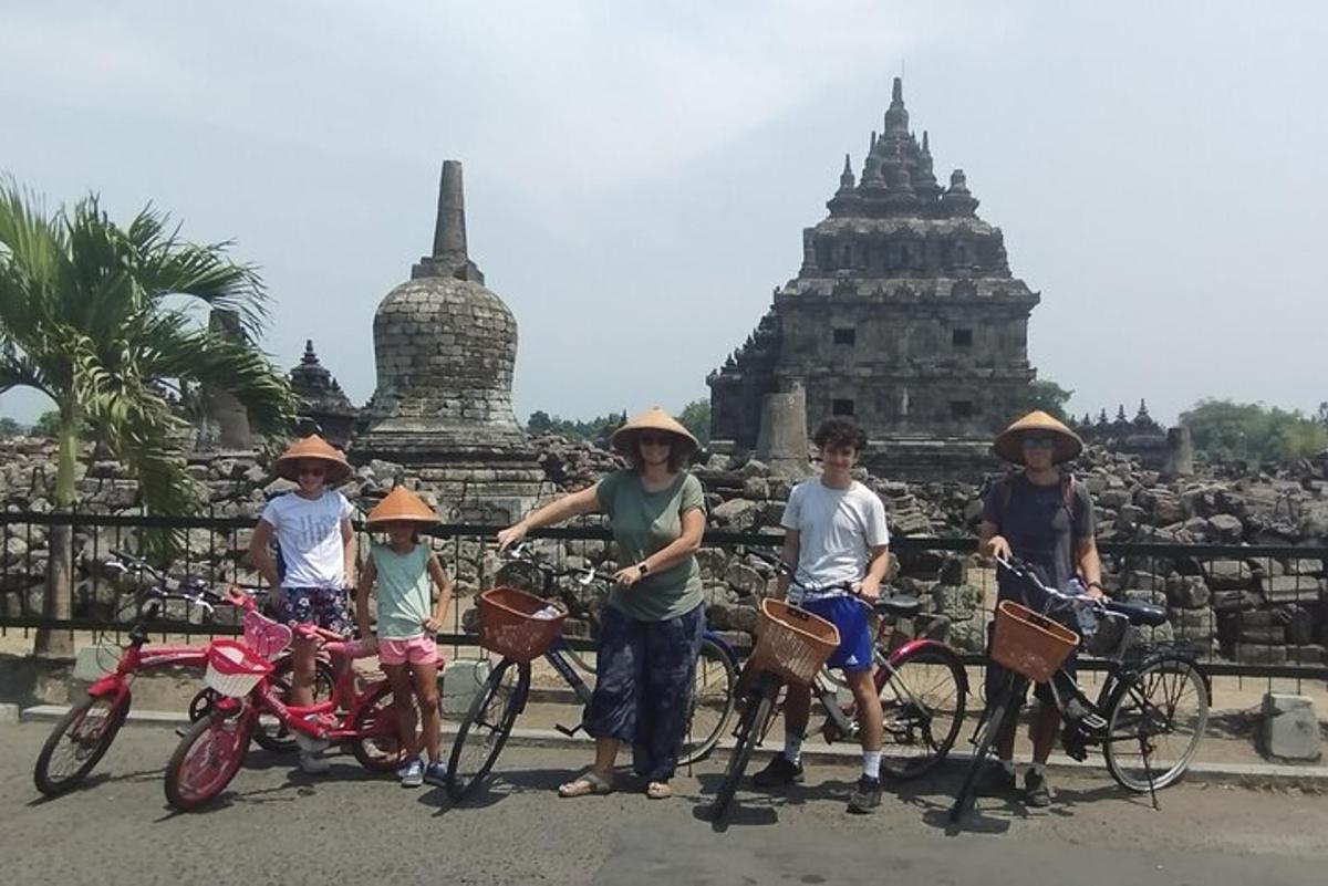sekumpulan kanak-kanak dengan basikal mereka di hadapan kuil