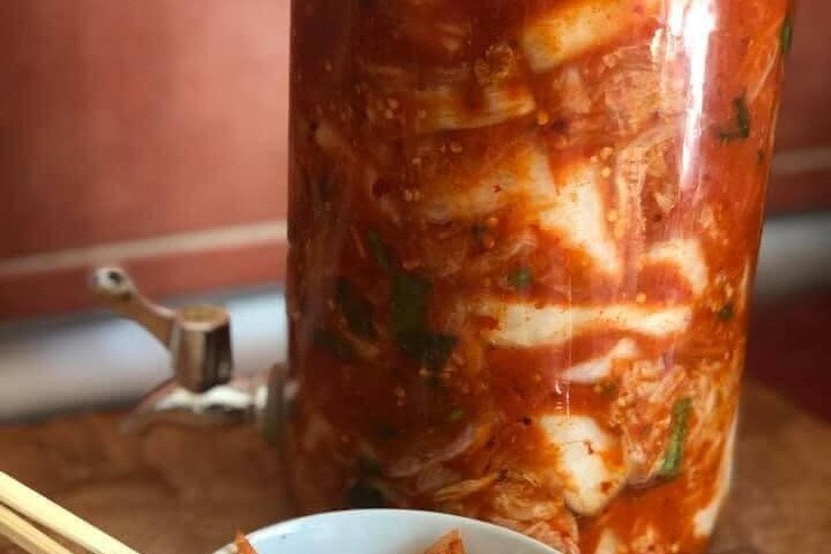 a jar of soup next to a plate of food