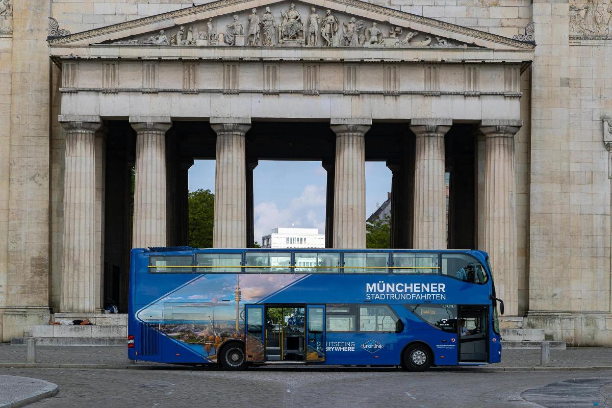 a blue double decker bus parked in front of a building