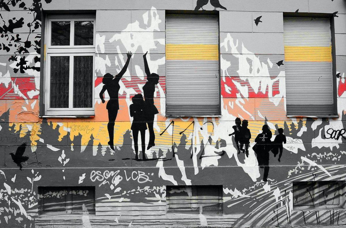 o pictură murală cu oameni pe lateralul unei clădiri