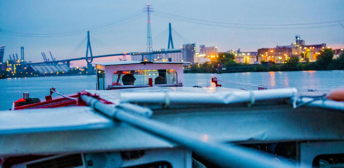 เรือบนน้ำพร้อมเมืองเป็นฉากหลัง
