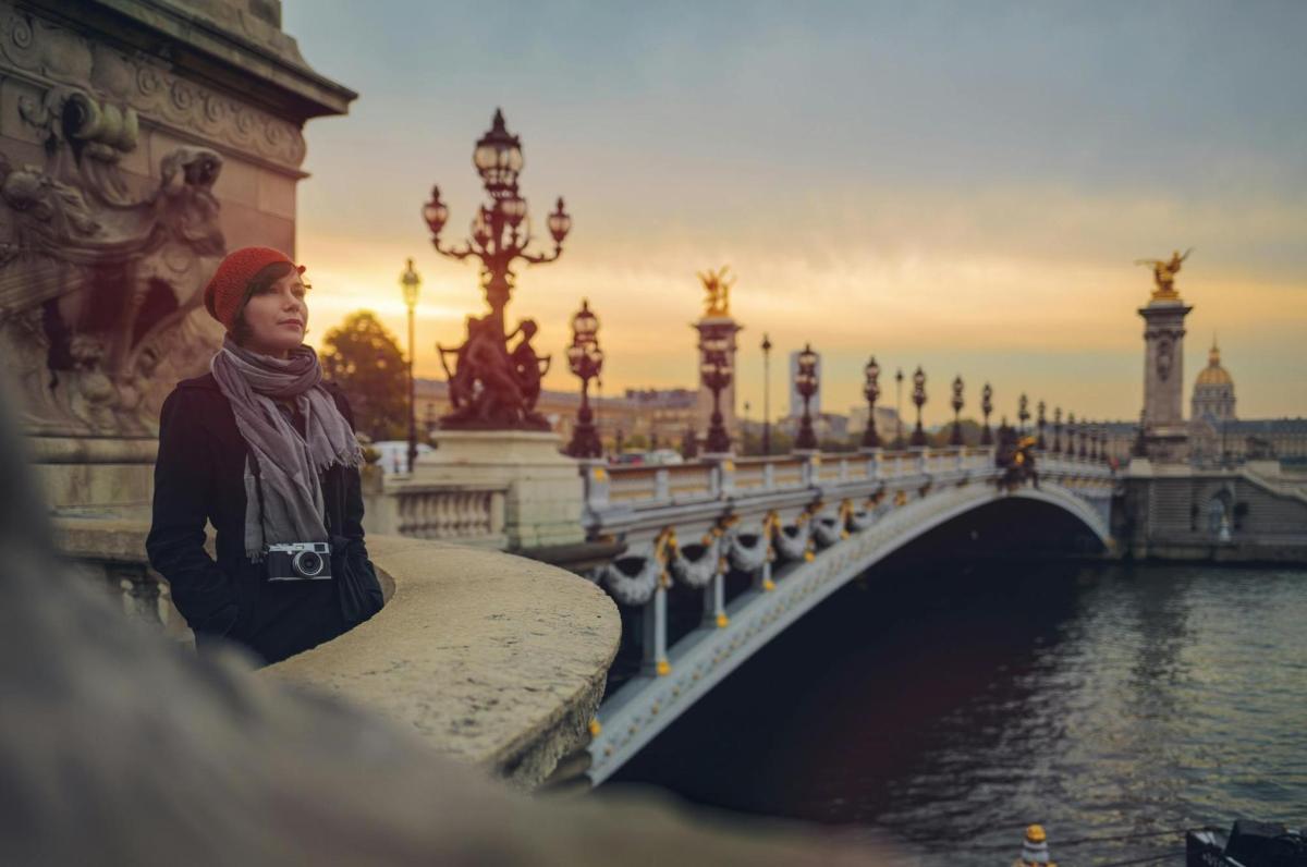 a woman standing on a bridge over a river