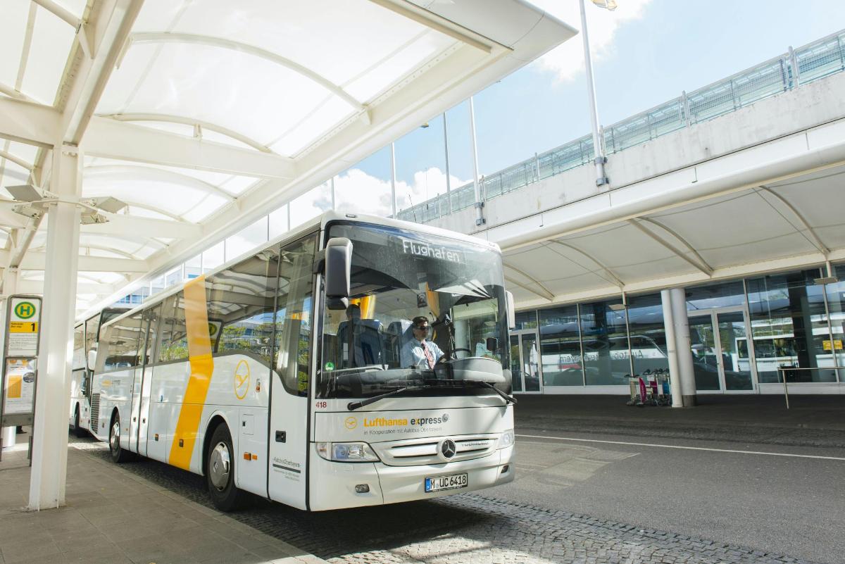 bel avtobus parkiran pod stavbo