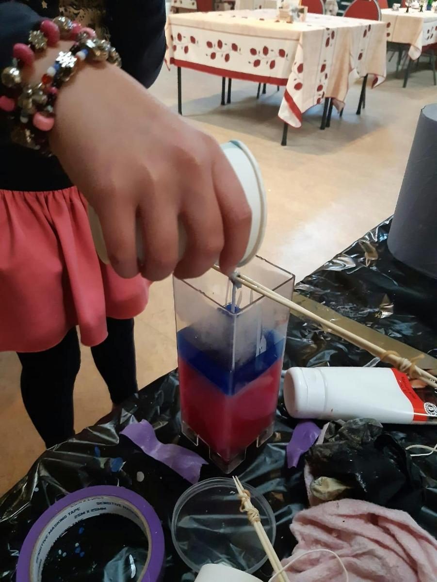 osoba držící brčko v nápoji na stole