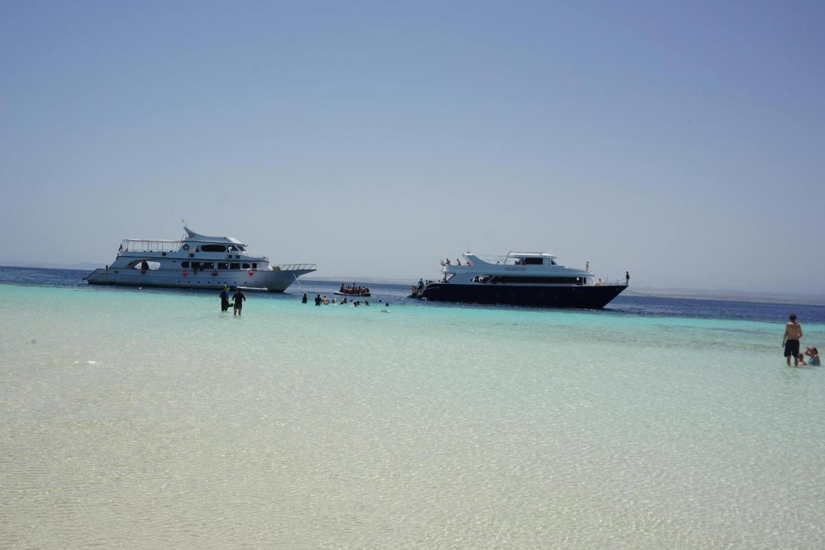 deux bateaux amarrés sur une plage avec des gens sur la plage