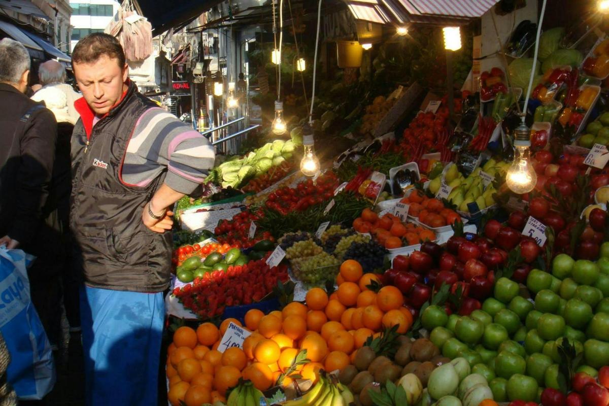 a man standing in a market with fruits and vegetables