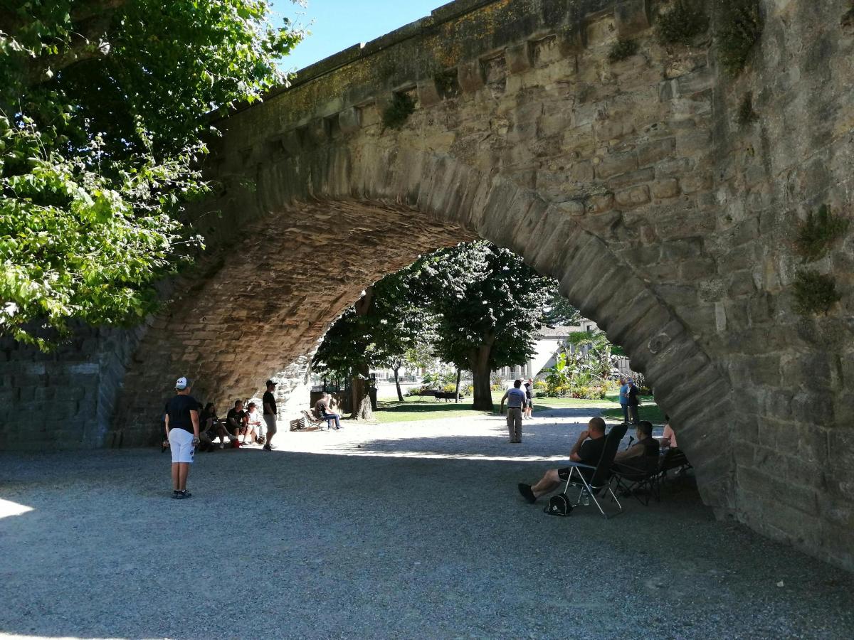 a stone bridge with people sitting under it